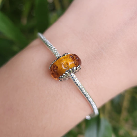 Ajoutez une touche de majesté et de couleur à votre collection avec ce charm en verre de Murano représentant le Roi Lion de Disney. Fabriqué en argent sterling 925 et verre de Murano de haute qualité, ce charm est compatible avec tous les bracelets Pandora, garantissant une intégration parfaite à votre bijou préféré. Parfait pour les fans du Roi Lion et de l'univers Disney, ce charm capture la grandeur et la beauté de la savane africaine avec des détails minutieusement travaillés, ajoutant une note de magie