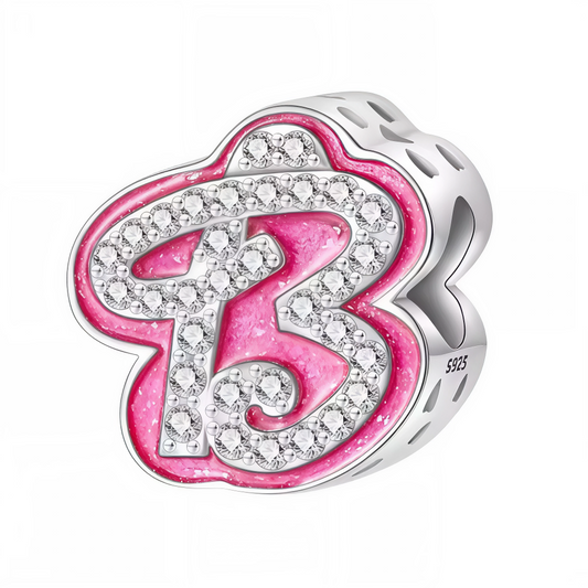 Apportez une touche glamour et fun à votre bracelet avec ce charm en forme de lettre "B", réalisé en argent 925 avec une finition rose brillante et orné de strass blancs scintillants. Un bijou tendance et pétillant, parfait pour afficher un style unique inspiré de l’univers Barbie, ou offrir un cadeau chic et coloré à un être cher.