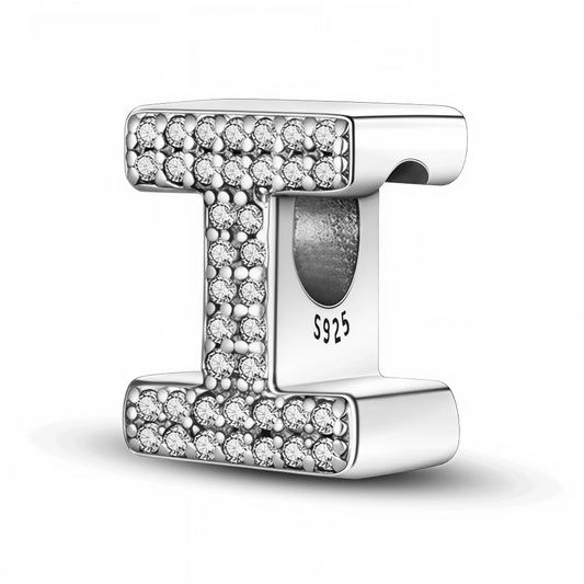 Affirmez votre style avec ce charm en forme de lettre "I", réalisé en argent 925 et délicatement orné de strass étincelants. Ce bijou raffiné est idéal pour personnaliser votre bracelet avec une touche lumineuse, que ce soit pour une initiale personnelle ou un mot porteur de sens.