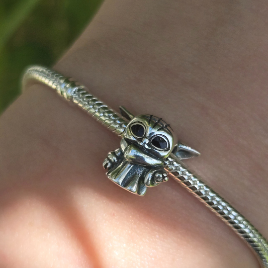 Ajoutez une touche de sagesse et de mystère galactique à votre collection avec ce charm représentant le Maître Yoda, le célèbre Jedi de Star Wars. Conçu en argent sterling S925, ce charm capture avec précision la sagesse et l'aura mystique du légendaire Maître Yoda.