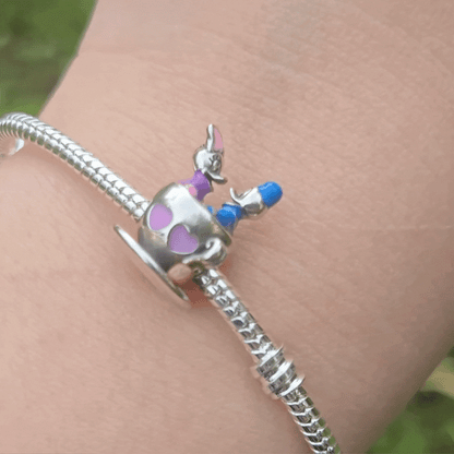 Le Charm Manège Donald et Daisy capture un moment enchanteur de Donald et Daisy profitant d’un tour de manège magique. Ce charm est un clin d'œil à l'univers ludique de Disney, parfait pour les collectionneurs et les amateurs de l'univers de Mickey et ses amis.