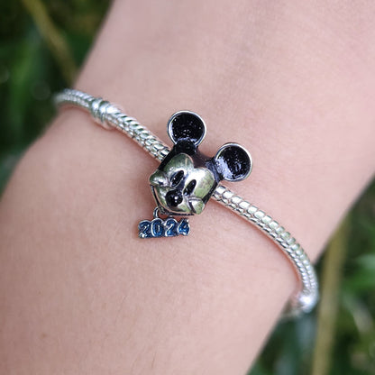 Commencez l'année 2024 avec un éclat de magie Disney grâce à ce charm exclusif représentant Mickey Mouse. Fabriqué en argent sterling 925, ce charm commémoratif célèbre l'année 2024 avec une gravure spéciale et la silhouette emblématique de Mickey. Ce charm est parfait pour marquer un moment spécial ou pour simplement ajouter une touche de fantaisie à votre bracelet, idéal pour les collectionneurs et les fans de l'univers Disney.