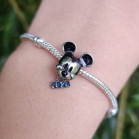 Commencez l'année 2024 avec un éclat de magie Disney grâce à ce charm exclusif représentant Mickey Mouse. Fabriqué en argent sterling 925, ce charm commémoratif célèbre l'année 2024 avec une gravure spéciale et la silhouette emblématique de Mickey. Ce charm est parfait pour marquer un moment spécial ou pour simplement ajouter une touche de fantaisie à votre bracelet, idéal pour les collectionneurs et les fans de l'univers Disney.