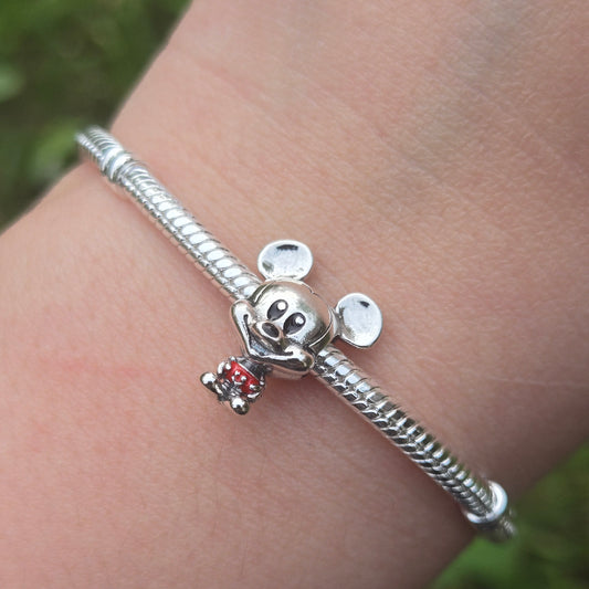 Ajoutez une touche classique et emblématique à votre collection avec ce charm représentant Mickey Mouse dans son célèbre pantalon rouge. Fabriqué en argent sterling 925, ce charm de haute qualité est compatible avec tous les bracelets Pandora, garantissant une intégration parfaite à votre bijou préféré. Parfait pour les fans de Mickey Mouse et de l'univers Disney, ce charm capture le style intemporel et la personnalité joyeuse de Mickey avec des détails minutieusement travaillés, ajoutant une note de charme