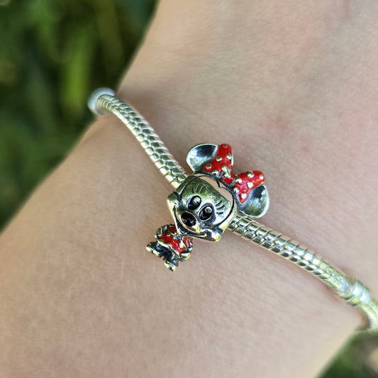 Ajoutez une touche de charme classique et de style à votre collection avec ce charm représentant Minnie Mouse dans sa robe emblématique à pois. Fabriqué en argent sterling 925, ce charm de haute qualité est compatible avec tous les bracelets Pandora, garantissant une intégration parfaite à votre bijou préféré. Parfait pour les fans de Minnie et de l'univers Disney, ce charm capture l'élégance et la joie de Minnie avec sa robe à pois rouges et son nœud assorti, ajoutant une note de glamour et de fantaisie à 