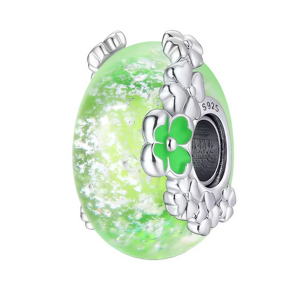 Ce charm en verre de Murano vert tendre affiche de jolis éclats blancs et translucides, qui rappellent la lumière filtrant à travers un sous-bois printanier. Autour de l’anneau en argent sterling&nbsp;925&nbsp;(gravé S925), une couronne de petites fleurs et un trèfle vert émaillé symbolisent la chance.