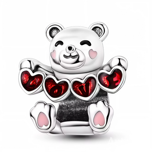 Ajoutez une touche de douceur et de tendresse à votre collection de bijoux avec ce charm en argent 925 représentant un ours assis, câlin et attendrissant. L’ours tient délicatement une banderole ornée de petits cœurs rouges éclatants, symbole d’amour et de complicité. Son fini argenté brillant met en valeur chaque détail du pelage, pour un effet à la fois chaleureux et raffiné. Un charm parfait pour exprimer vos émotions avec élégance.