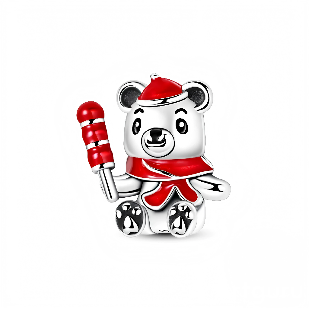 Le petit ours en argent 925 affiche un visage expressif avec de grands yeux noirs et des coussinets de pattes en forme de cœurs, ce qui accentue son côté attendrissant. Son bonnet, son foulard et la sucette qu’il tient sont recouverts d’un émail rouge brillant avec des touches blanches, rappelant les couleurs classiques de Noël. L’ensemble évoque la chaleur et la gourmandise des fêtes de fin d’année.
