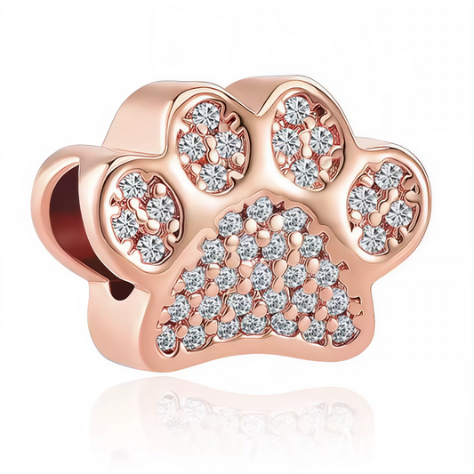 Craquez pour l’élégance et la douceur de ce charm en forme de patte de chien, sublimé par une finition or rose et un pavage de cristaux blancs scintillants ! Ce bijou raffiné est parfait pour personnaliser votre bracelet, afficher votre amour des chiens ou offrir un cadeau précieux à tous les amoureux des animaux de compagnie.