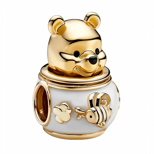 Ajoutez une dose de tendresse à votre collection avec ce charm unique, incarnant Winnie l’Ourson dans sa posture préférée : près d’un pot de miel débordant de douceur. Retrouvez toute la magie des contes Disney à travers cette création lumineuse, idéale pour accompagner vos plus beaux instants gourmands et féeriques.

Ce charm séduit par ses détails minutieux : la silhouette chaleureuse de Winnie coiffant un pot de miel nacré, décoré d’une abeille stylisée et d’une fleur délicate. Chaque reflet doré rappell
