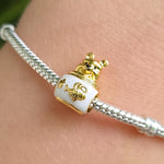 Ajoutez une dose de tendresse à votre collection avec ce charm unique, incarnant Winnie l’Ourson dans sa posture préférée : près d’un pot de miel débordant de douceur. Retrouvez toute la magie des contes Disney à travers cette création lumineuse, idéale pour accompagner vos plus beaux instants gourmands et féeriques.

Ce charm séduit par ses détails minutieux : la silhouette chaleureuse de Winnie coiffant un pot de miel nacré, décoré d’une abeille stylisée et d’une fleur délicate. Chaque reflet doré rappell