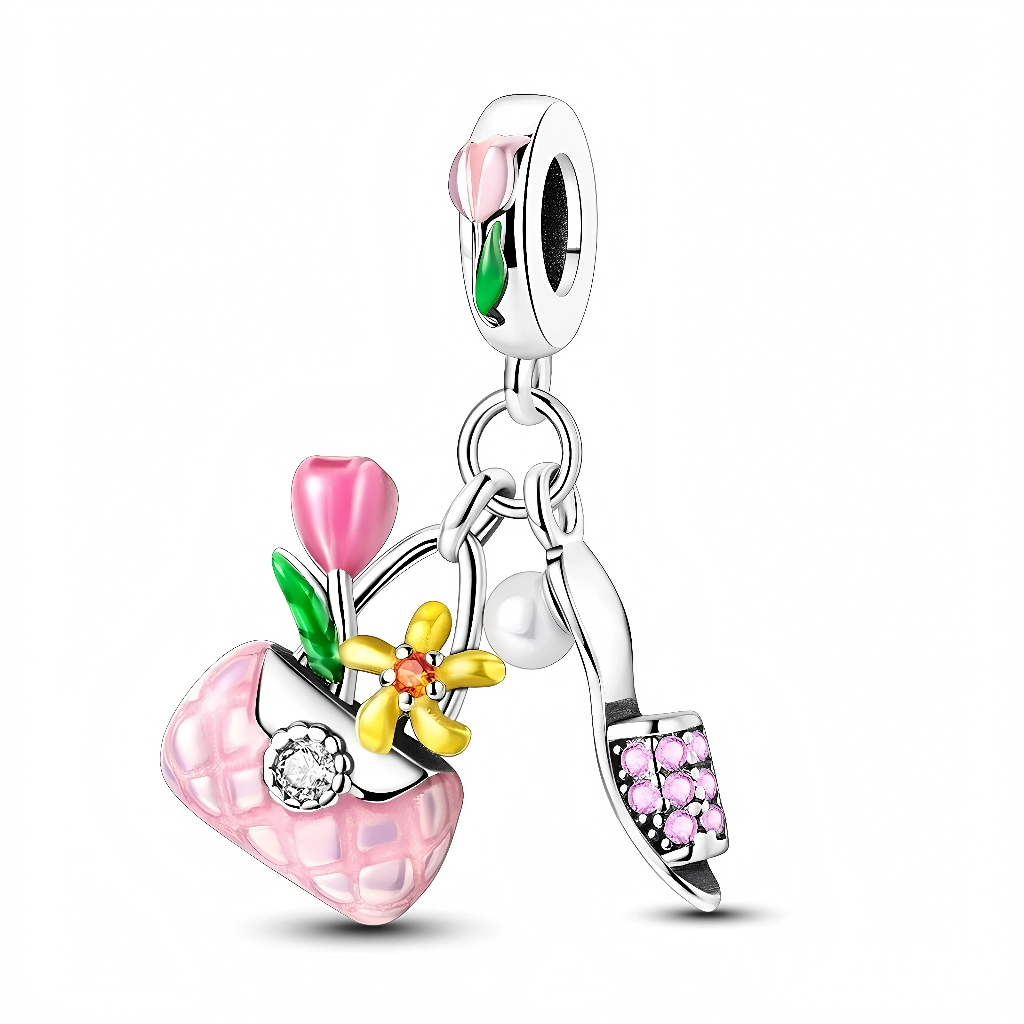 Ce charm pendant en argent 925 réunit trois breloques féminines : un petit sac matelassé rose orné d’une fleur jaune et d’une tulipe rose, un escarpin à talon pavé de strass roses, et une mini perle blanche suspendue au centre. La bélière lisse est décorée d’une tulipe rose et verte en émail, créant un ensemble coloré et printanier.

Caractéristiques :

-Matière : Argent 925 avec émail coloré et zirconia roses.
-Design : Bélière fleurie supportant un sac matelassé, un escarpin strassé et une petite perle.
-