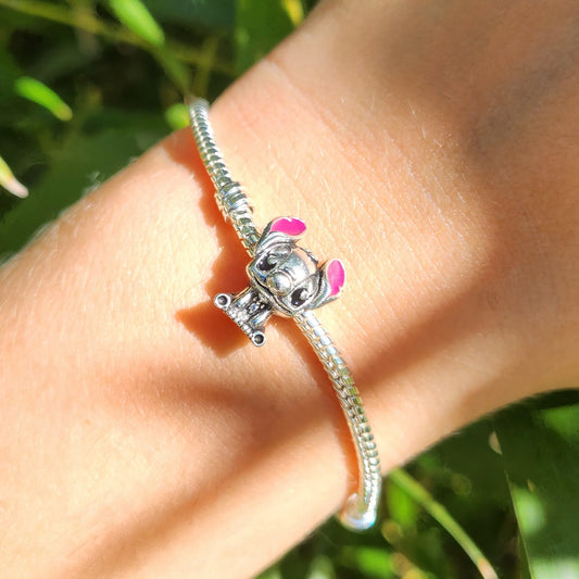 Ajoutez une touche de fun et d'exotisme à votre collection avec ce charm représentant Stitch, le personnage emblématique de Lilo et Stitch. Fabriqué en argent sterling 925, ce charm de haute qualité est compatible avec tous les bracelets Pandora, garantissant une intégration parfaite à votre bijou préféré. Parfait pour les fans de Stitch et de l'univers Disney, ce charm capture l'esprit espiègle et la personnalité unique de l'extraterrestre avec des détails minutieusement travaillés, ajoutant une note de fa