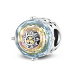 Ce charm en&nbsp;argent&nbsp;925 se présente sous la forme d’un barillet orné sur chaque face d’un large cristal facetté aux reflets multicolores. Au centre du cristal se trouve un petit tournesol argenté, dont le cœur est pavé de pierres jaunes scintillantes, évoquant un rayon de soleil emprisonné dans le cristal.