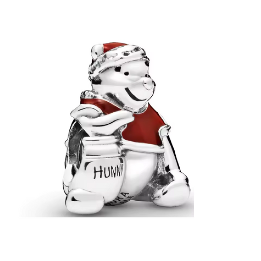 Ajoutez une touche adorable et festive à votre collection avec ce charm Winnie l'Ourson en costume de Père Noël. Confectionné en métal argenté avec des détails en émail rouge, blanc et doré, ce charm montre Winnie l'Ourson vêtu d'un costume de Père Noël, portant un sac rempli de cadeaux, prêt à partager la magie des fêtes. Son expression joyeuse et ses couleurs chaleureuses apportent une ambiance douce et festive, idéale pour les fans de Disney qui aiment célébrer la saison avec un compagnon iconique. Compa