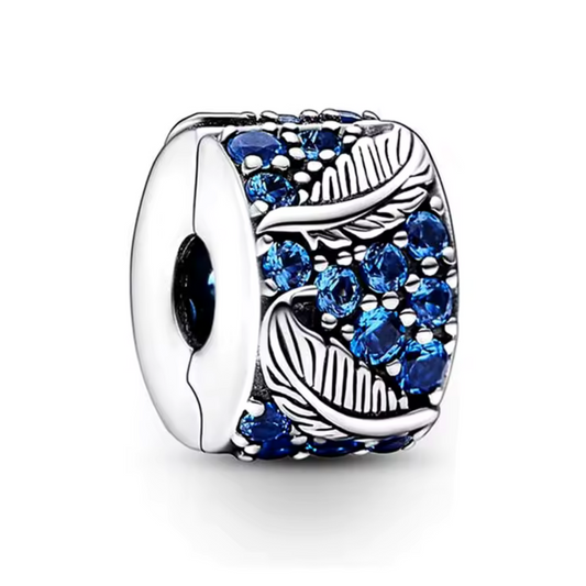 Évoquez légèreté et grâce avec le Charm Clips - Plume Courbe et Pavé. Conçu en argent sterling S925, ce charm représente une plume délicatement incurvée, ornée de petits pavés scintillants, symbolisant l'élégance et la liberté. Le design finement travaillé et ses pierres brillantes ajoutent une touche subtile de raffinement à votre bracelet tout en maintenant vos autres charms parfaitement en place.