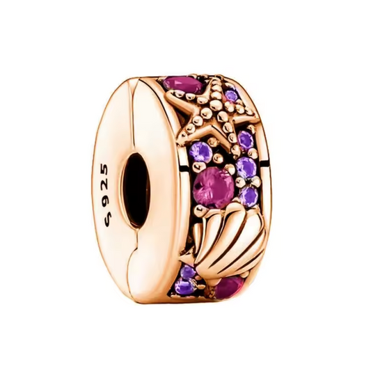 Ajoutez une touche de douceur marine à votre bracelet avec ce charm clips Coquillage aux teintes roses et violettes. Avec ses détails perlés et ses couleurs délicates, il évoque l'élégance des trésors marins tout en sécurisant vos charms avec style.