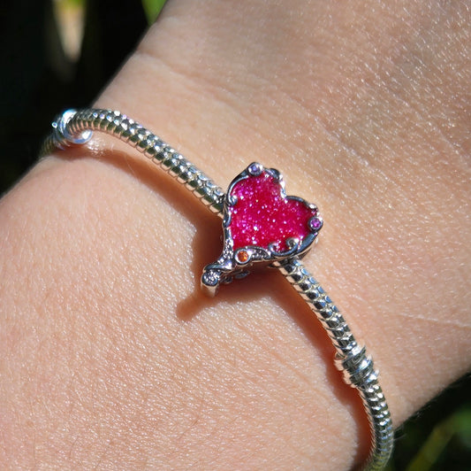 Apportez une touche de tendresse à votre bracelet avec ce charm en forme de coeur rose. En argent 925, il est émaillé d'une teinte délicate qui exprime l'amour pur et simple.