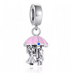 Laissez-vous séduire par ce charm raffiné représentant un couple enlacé sous un parapluie rose, symbole intemporel de tendresse et de protection. Conçu en argent 925, il met en scène deux personnages adorables, protégés ensemble de la pluie sous un dôme pastel orné d’un petit cristal bleu étincelant. Un bijou tout en finesse pour célébrer l’amour, le partage et les moments précieux à deux, idéal à offrir ou à ajouter à votre collection pour exprimer votre côté romantique au quotidien. Compatible avec la plu