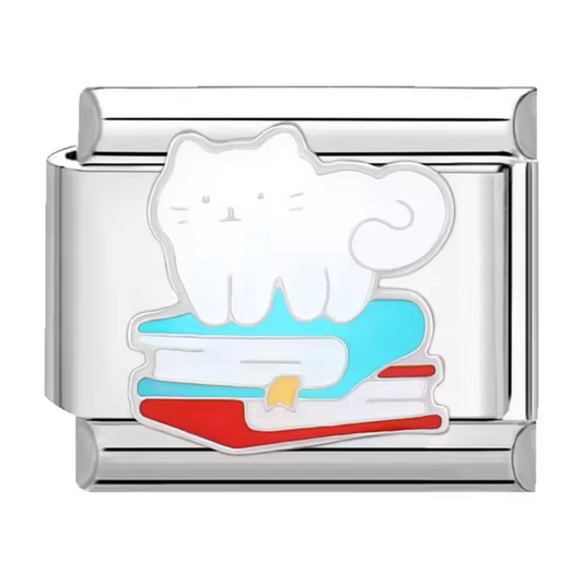 Ce charm italien en acier inoxydable argenté représente un adorable chat blanc perché sur une pile de livres, une scène qui séduira les amoureux des félins et de la lecture. Avec ses détails raffinés et son design plein de poésie, il apporte une touche d’élégance et de personnalité à votre bracelet. Facile à fixer, il s’adapte parfaitement à nos bracelets composés de 17 maillons extensibles et réglables, convenant à toutes les tailles de poignet. Compatible avec tous nos charms italiens