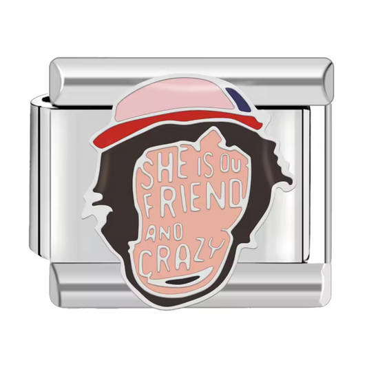 Ce charm italien représente le visage de Dustin Henderson, accompagné de l’inscription “She is Friends and Crazy”, une citation pleine de charme et d’humour inspirée de Stranger Things. Fabriqué en acier inoxydable de haute qualité, il allie robustesse et finesse des détails pour un rendu unique. Facile à fixer, il s’adapte à nos bracelets composés de 17 maillons extensibles et réglables, convenant à toutes les tailles de poignet. Compatible avec tous nos charms italiens, ce bijou apporte une touche geek or