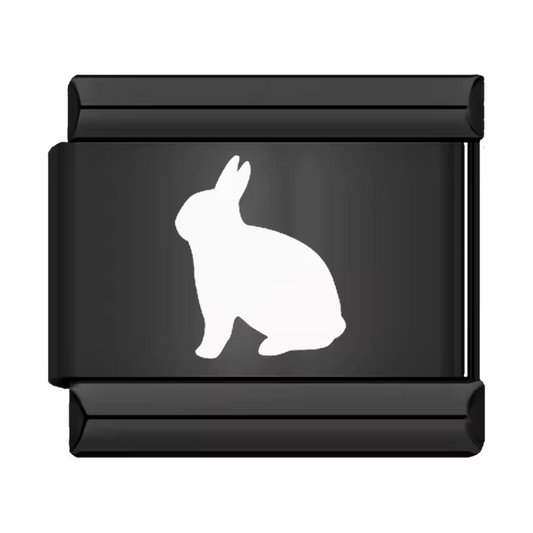 Ce charm italien en acier inoxydable noir met en valeur un adorable lapin blanc, symbole de douceur et de malice. Son design contrasté et raffiné apporte une touche d’élégance et d’originalité à votre bracelet. Facile à fixer, il s’adapte parfaitement à nos bracelets composés de 17 maillons extensibles et réglables, convenant à toutes les tailles de poignet. Compatible avec tous nos charms italiens, ce bijou est parfait pour personnaliser votre bracelet avec une note animale et poétique.