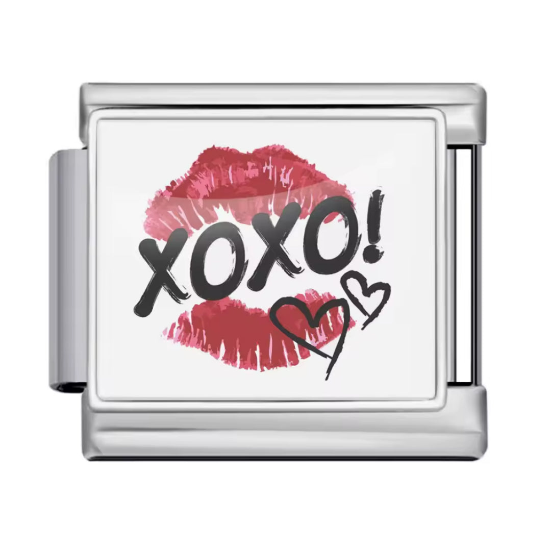 Affichez une allure chic et mystérieuse avec ce charm italien en&nbsp;argent&nbsp;inspiré des codes du glamour et des messages secrets. Orné d’une trace de lèvre et du mot&nbsp;XOXO, il évoque les baisers, les rumeurs et l’élégance des univers les plus tendance. Un bijou raffiné et audacieux, parfait pour apporter une touche fashion, féminine et irrésistible à votre collection.

Caractéristiques :

- Matière : Argent 925.
- Thème : Glamour, amour, secrets, mode.
- Design : Trace de lèvre, inscription XOXO, 