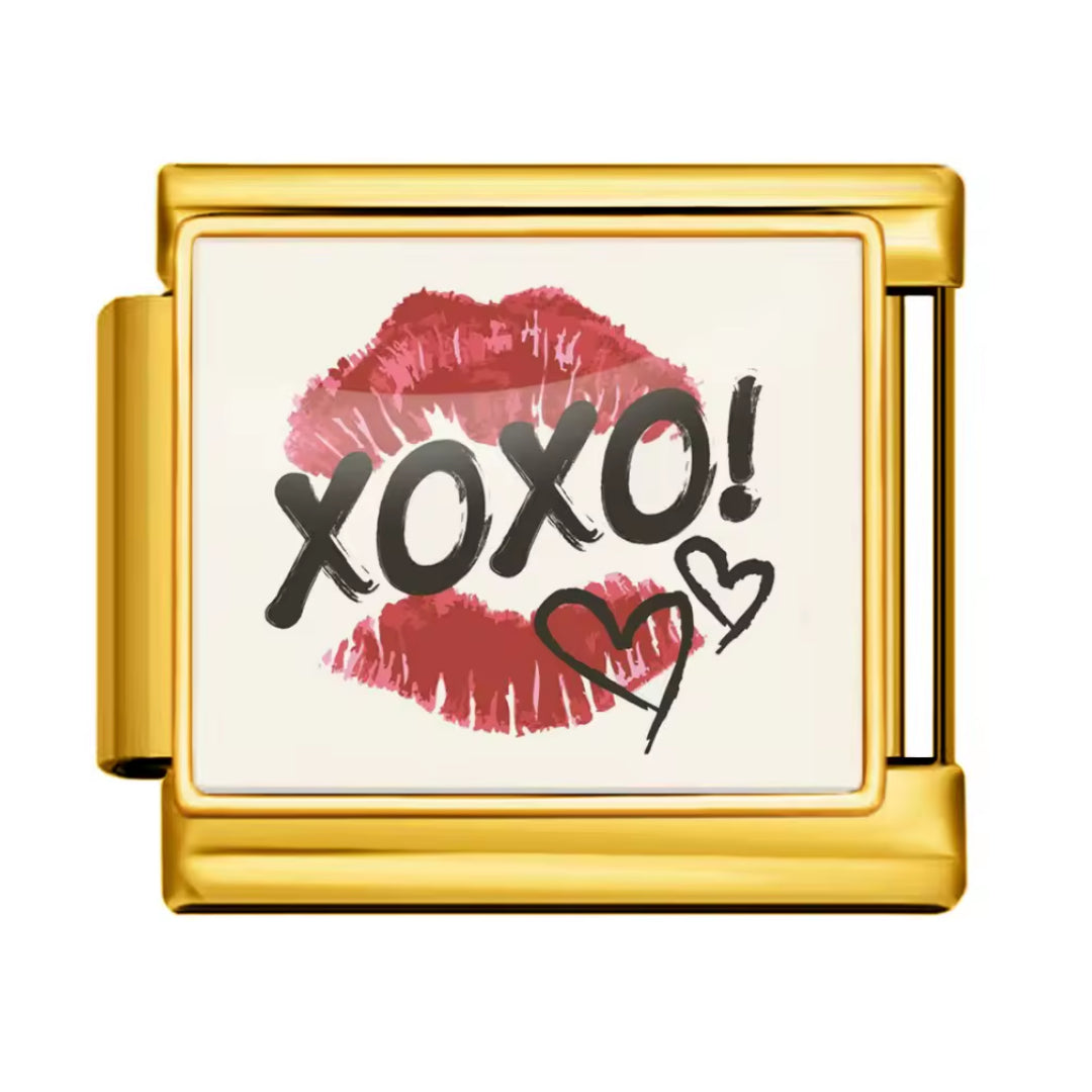 Affichez une allure chic et mystérieuse avec ce charm italien en&nbsp;doré&nbsp;inspiré des codes du glamour et des messages secrets. Orné d’une trace de lèvre et du mot&nbsp;XOXO, il évoque les baisers, les rumeurs et l’élégance des univers les plus tendance. Un bijou raffiné et audacieux, parfait pour apporter une touche fashion, féminine et irrésistible à votre collection.

Caractéristiques :

- Matière : Doré.
- Thème : Glamour, amour, secrets, mode.
- Design : Trace de lèvre, inscription XOXO, style ch