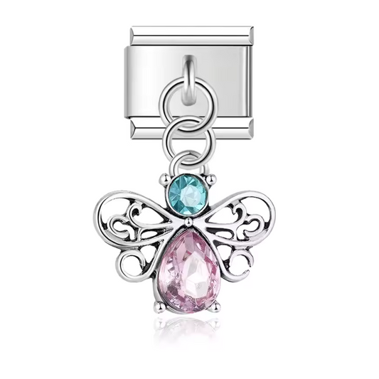 Ce charm italien pendentif en acier inoxydable argenté met en valeur une abeille stylisée, ornée de détails brillants bleu et rose qui lui donnent un éclat doux et lumineux. Symbole d’harmonie, de travail et de nature, cette abeille colorée apporte une touche joyeuse et délicate à votre bracelet. Son format pendentif ajoute du mouvement et capte la lumière avec élégance. Facile à accrocher, il s’adapte à nos bracelets composés de 17 maillons extensibles et réglables, convenant à toutes les tailles de poigne