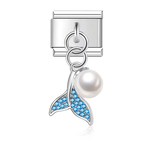 Ce charm pendentif italien en acier inoxydable argenté représente un dauphin formant un cœur délicat, agrémenté d’une perle au centre. Disponible en bleu, rose ou vert, il incarne la tendresse et l’élégance marine. Parfait pour personnaliser votre bracelet, ce pendentif s’adapte à nos bracelets composés de 17 maillons extensibles et réglables, convenant à toutes les tailles de poignet. Compatible avec tous nos charms italiens, il est idéal pour ajouter une touche raffinée et océanique à votre collection.