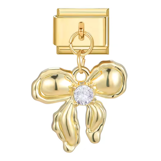 Ce charm italien doré s’orne d’un pendentif en forme de nœud, symbole de lien précieux et d’élégance féminine. Sa brillance chaude et sa finition soignée apportent une touche de raffinement à tout bracelet, alliant charme intemporel et douceur romantique. Un bijou délicat qui célèbre les petits détails qui font toute la différence.