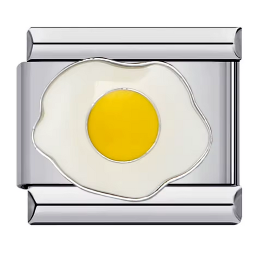 Ce charm italien gourmand représente un œuf au plat délicatement détaillé, symbole de simplicité et de convivialité matinale. Confectionné en acier inoxydable argenté de haute qualité, il séduit par ses finitions soignées et son éclat durable. Facile à fixer, il s’adapte parfaitement à nos bracelets composés de 17 maillons extensibles et réglables, adaptés à tous les poignets. Compatible avec tous nos charms italiens, ce bijou chaleureux apporte une touche ludique et authentique à votre collection.