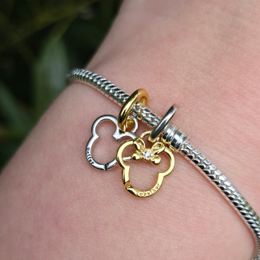 Ajoutez un peu de magie Disney à votre bracelet avec le Charm à Partager Disney Mickey et Minnie, finement conçu en argent 925. Ce charm unique se divise en deux parties, l'une représentant Mickey et l'autre Minnie, symbolisant l'amour, la complicité et les moments partagés. Parfait pour les amoureux de l'univers Disney, il incarne l'esprit de la romance et de l'amitié éternelle.

Offrez une moitié à un être cher pour marquer un lien spécial ou conservez les deux parties pour célébrer l'unité et la magie de