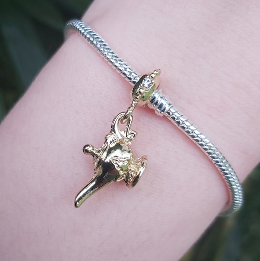 Faites un vœu et laissez-vous emporter par la magie avec ce charm représentant la célèbre lampe d'Aladdin. Disponible en argenté ou doré, ce bijou en argent 925 incarne l'enchantement et les mystères des contes orientaux. Parfait pour les rêveurs, les amateurs de contes et les passionnés de l'univers d'Aladdin, ce charm est un hommage à la magie, aux génies et aux souhaits exaucés.