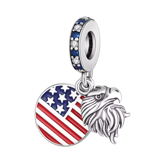 Affichez fièrement les symboles de la liberté et du patriotisme avec le Charm - Aigle et Drapeau des États-Unis, en argent sterling S925. Ce charm combine la majesté de l'aigle, emblème national américain, et les étoiles et rayures du célèbre drapeau des États-Unis. Idéal pour les voyageurs, les amoureux de la culture américaine ou ceux qui souhaitent porter un symbole de fierté et de force.