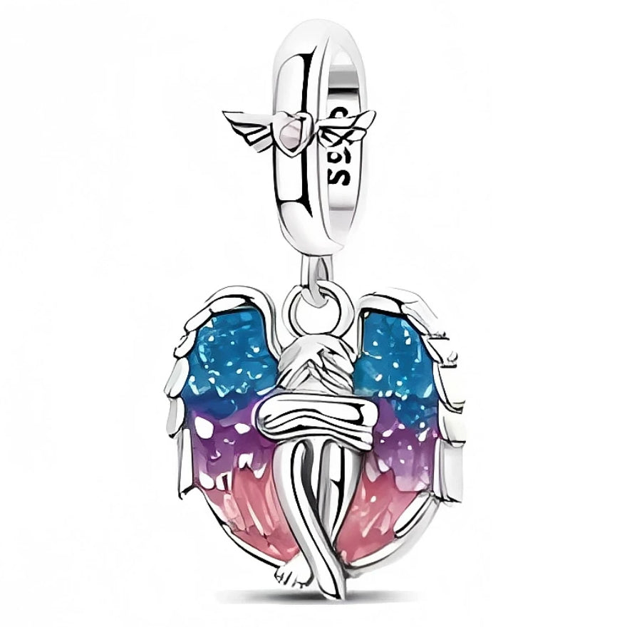 Ce charm représente une silhouette d’ange assis, entouré de grandes ailes déployées en argent 925 remplies d’émaux dégradés bleu, violet et rose pour un effet ciel au crépuscule. La bélière lisse est décorée d’un petit motif ailé discret, ajoutant une touche de douceur et de protection à l’ensemble, idéal à porter au quotidien ou pour marquer un souvenir précieux.