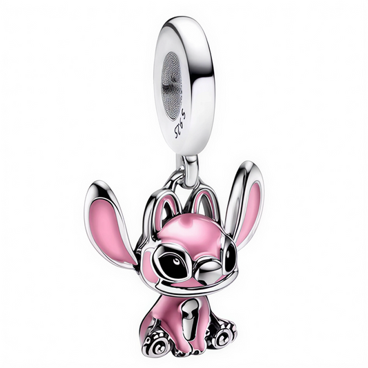 Apportez une touche de douceur intergalactique à votre collection avec ce charm pendentif représentant Angel, la compagne de Stitch, dans une position assise pleine de tendresse. Réalisé avec une finition argentée brillante et des nuances de rose éclatant, ce bijou capture toute la délicatesse et le charme de ce personnage adoré. Avec ses grandes oreilles, ses yeux expressifs et sa pose attendrissante, Angel séduira tous les fans de l’univers Lilo et Stitch.