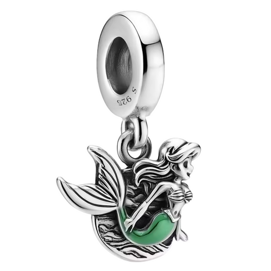 Plongez sous les mers avec ce charm pendentif représentant Ariel, la célèbre petite sirène, finement réalisée en Argent 925 (S925). Son corps argenté brillant est sublimé par une queue aux reflets verts éclatants, capturant toute la magie et la beauté de ce personnage emblématique. Un bijou parfait pour les amoureux de Disney et des aventures marines.