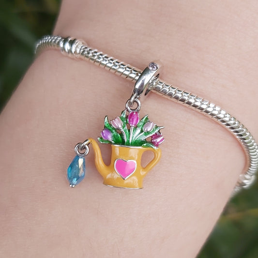 Ajoutez une touche de fraîcheur et de poésie à votre collection avec ce ravissant Charm Arrosoir Fleuri. Fabriqué en argent 925, ce charm représente un arrosoir miniature débordant de fleurs délicates, symbolisant la beauté de la nature et la joie de faire fleurir vos rêves. Chaque détail est finement travaillé pour capturer l’élégance et le charme des jardins en pleine floraison.

Parfait pour les amoureux de la nature et du jardinage, ce charm est une célébration de la vie, de la croissance et du renouvea