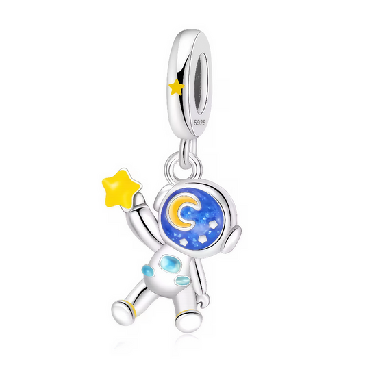 Embarquez pour l’infini avec ce charm astronaute lumineux, parfait pour donner une touche céleste à vos bijoux ! Son casque décoré d’un ciel étoilé et sa petite étoile jaune capturent toute la magie des rêves cosmiques. De jour comme de nuit, il ne passe jamais inaperçu : certains détails s’illuminent dans le noir, pour un effet “glow in the dark” fascinant et unique. Ce bijou en argent 925 est conçu pour celles et ceux qui veulent explorer l’univers et porter leur imagination partout.