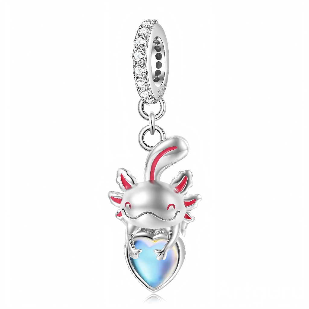 Suspendu à une bélière pavée de petits zircons, l’axolotl en argent arbore un large sourire et des branchies rosées qui ressortent délicatement sur le métal brillant. Entre ses pattes, il tient un grand cœur en pierre opalescente aux reflets bleus, qui change de couleur selon la lumière et évoque un trésor aquatique. L’ensemble crée un bijou ludique et attendrissant, parfait pour symboliser la bienveillance, la singularité et l’amour qui sort de l’ordinaire.