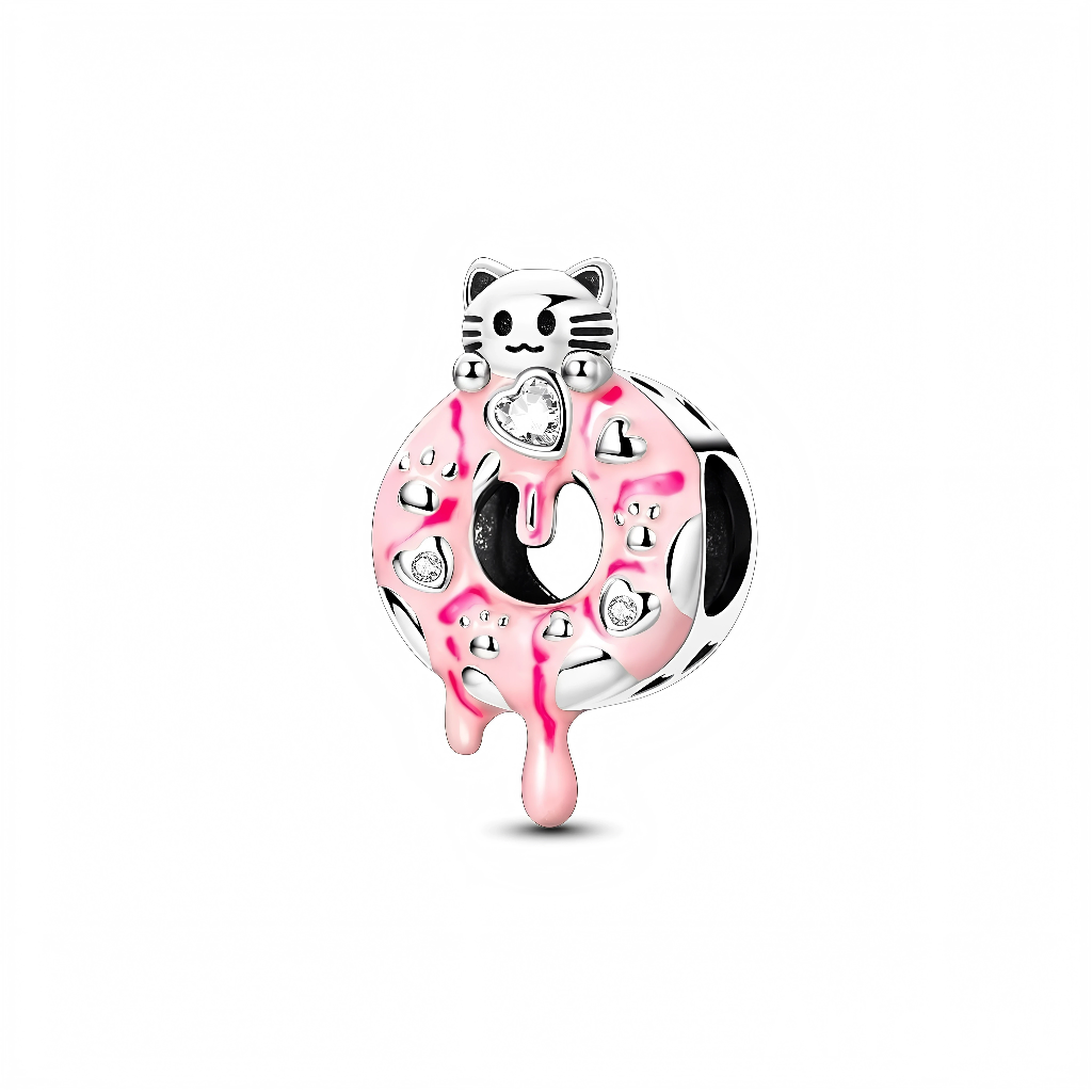 Ce charm en argent 925 représente un donut gourmand recouvert d’un glaçage rose brillant, qui coule en petites gouttes vers le bas, serti de quelques zircons clairs façon « sprinkles ». Sur le haut du donut se tient une petite tête de chat stylisée, avec museau, moustaches gravées et oreilles pointues, pour un rendu kawaii et ludique.