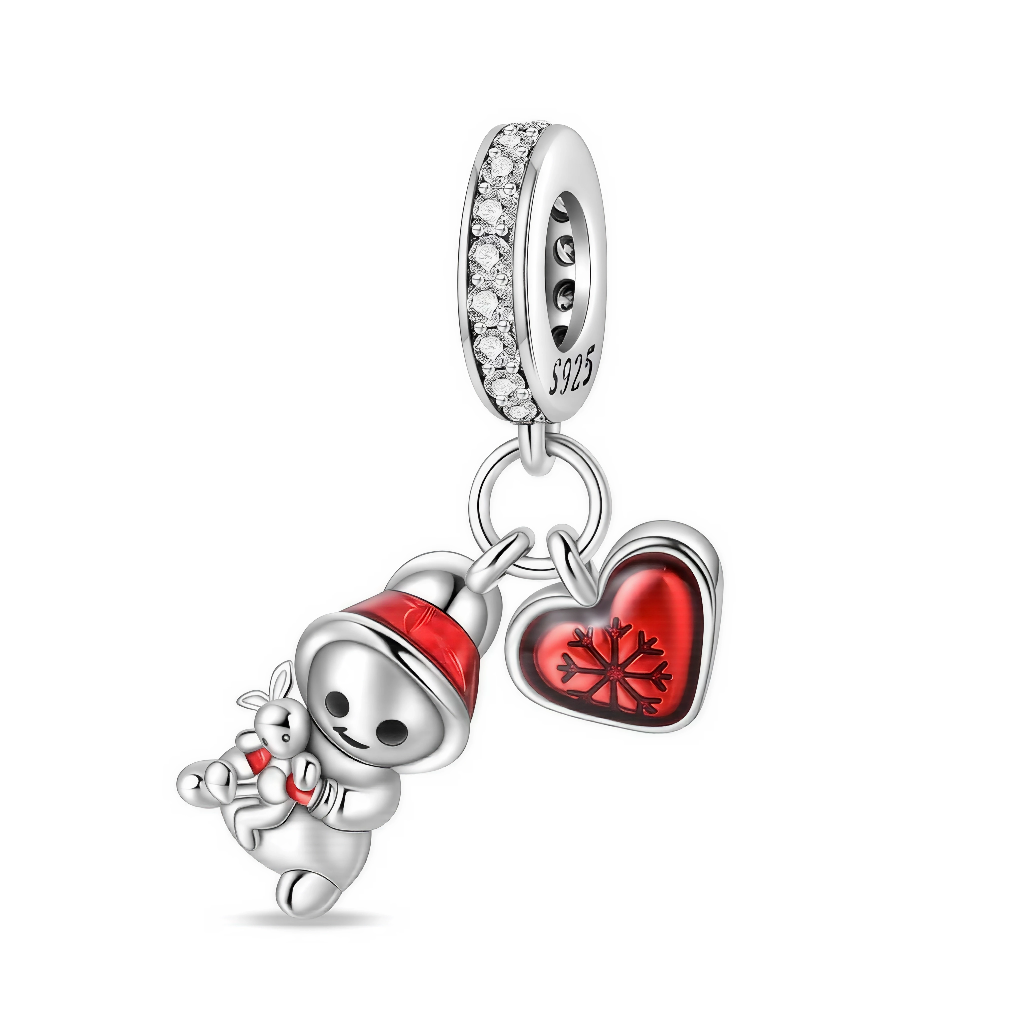 Ce charm pendentif en argent met en scène un petit bonhomme de neige coiffé d’un bonnet rouge, serrant un ours en peluche, accompagné d’un cœur rouge brillant décoré d’un flocon de neige. La bélière pavée de zircons clairs ajoute une touche d’éclat, parfaite pour célébrer l’hiver et l’esprit tendre de Noël.