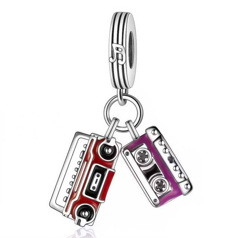 Ce charm rétro dynamique présente deux cassettes audio vintage : une rouge vif rectangulaire aux bobines noires visibles et une violette foncée compacte, reliées par une chaîne fine avec note musicale ornementale sur l'anneau supérieur. Les détails émaillés capturent l'essence groovy des années passées. Symbole de rythme nostalgique et énergie musicale, il pulse les bracelets d'un beat vintage irrésistible.

Caractéristiques

Matière : Argent 925 avec émail rouge, violet et noir.
Design : Double cassette 3D