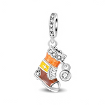La bélière en argent 925 est sertie de petites pierres claires qui ajoutent une touche scintillante. Le pendentif figure une botte haute décorée d’émail dégradé orange, jaune et brun, avec des motifs de croix et flocons, un revers façon fourrure pavé de cristaux, et un charm rond latéral serti d’une pierre transparente évoquant un flocon de neige.