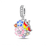 La bélière est pavée de zircons transparents, puis un médaillon ajouré rassemble plusieurs fleurs émaillées rose, bleu et blanc, chacune rehaussée de petites pierres aux couleurs assorties. À côté, un papillon multicolore aux ailes jaune, rouge et bleue semble se poser sur le bouquet, créant beaucoup de mouvement et de lumière à chaque geste du poignet.