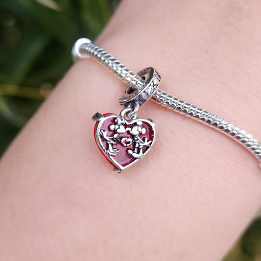 Célébrez l’amour et la magie avec ce charm en argent 925 représentant un cœur orné des célèbres silhouettes de Mickey et Minnie. Un bijou intemporel et romantique, parfait pour les fans des icônes Disney. Ce charm ajoute une touche de tendresse et de féérie à votre collection, symbolisant l’amour éternel.