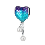 Ce charm pendentif en argent 925 adopte la forme d’un cœur recouvert d’écailles iridescentes, dans un dégradé bleu lagon et violet qui rappelle la queue d’une sirène. Deux petites perles blanches sont suspendues à de fines chaînettes sous le cœur, évoquant des gouttes d’eau ou des trésors marins.