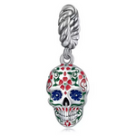 Ce charm en argent 925 reproduit un crâne calavera Day of the Dead émaillé de motifs floraux multicolores en rouge, vert et blanc sur fond crème, avec yeux bleus intenses et sourire joyeux dévoilant des dents parfaites, suspendu à une torsade tressée élégante. Il célèbre la tradition mexicaine vibrante et festif du Día de los Muertos, idéal pour un bracelet chargé de culture et de couleur.

Caractéristiques :

Matière : Argent 925
Design : Crâne calavera Day of the Dead émaillé de motifs floraux multicolore