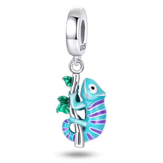 Découvrez ce charm pendentif en argent 925 représentant un caméléon bleu aux traits violets, délicatement perché en train de grimper sur une branche. Ce design coloré et dynamique capture parfaitement l’esprit changeant et unique de ce reptile fascinant. Une pièce originale pour les amateurs de bijoux pleins de caractère et de nature.